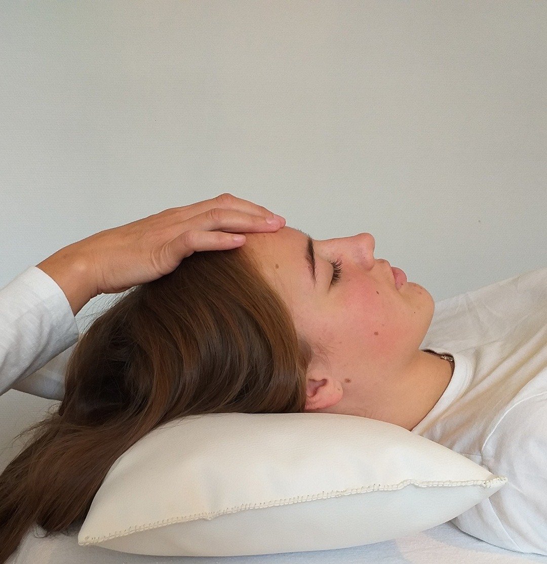 Femme allongée sur un coussin, recevant un massage shiatsu dans un cadre apaisant à Dieppe